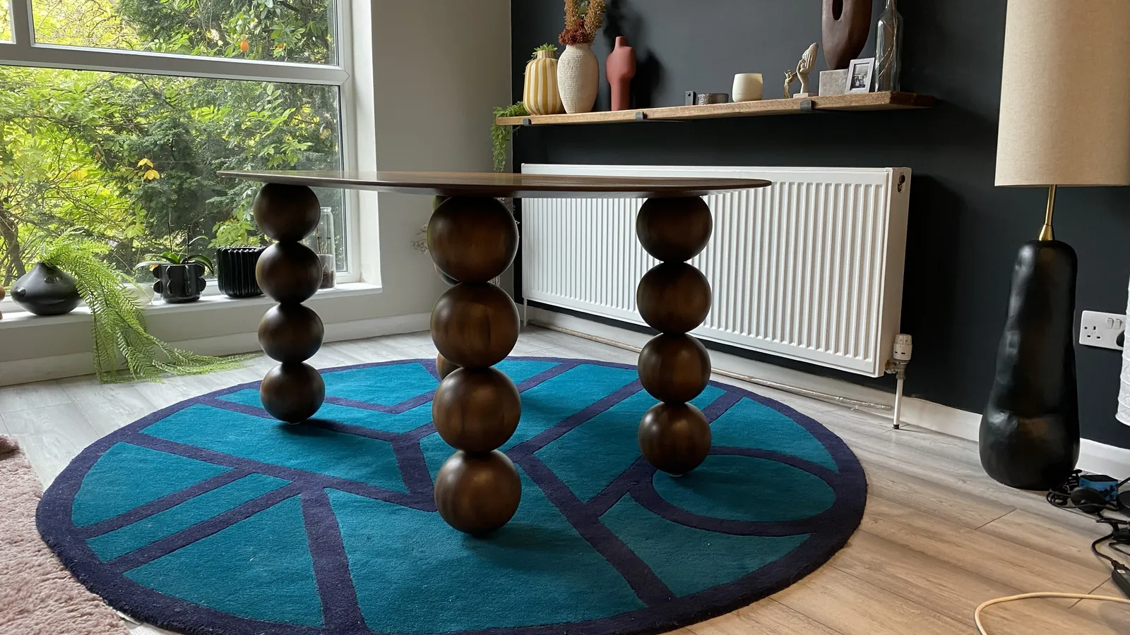 The Orbital dinette table from the side, legs of stacked turned spheres