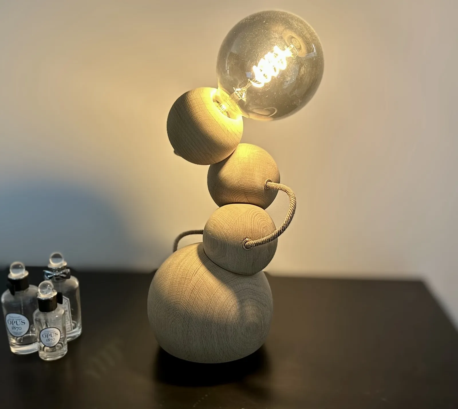 The Orbital table lamp lit, wooden spheres glowing