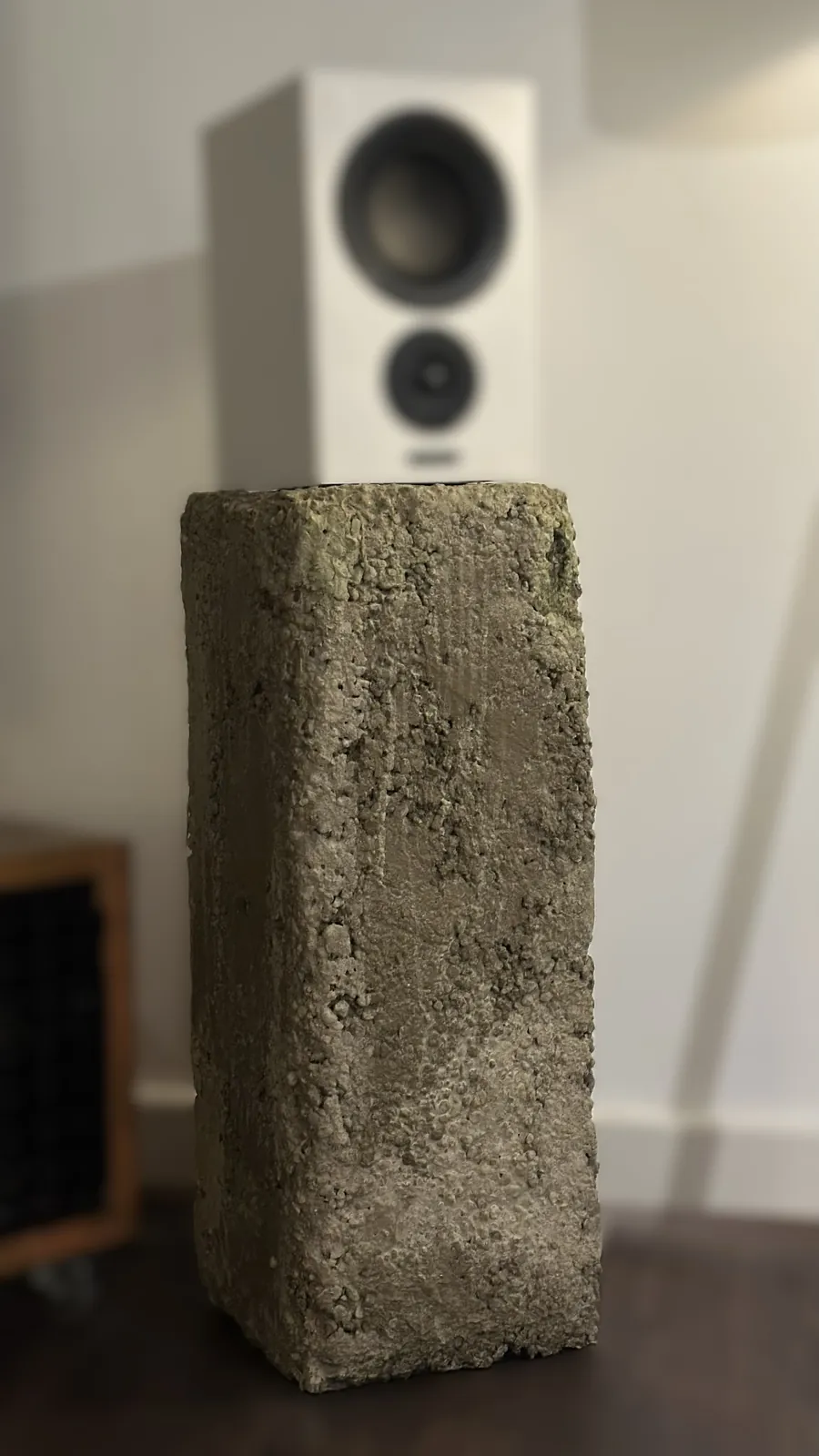 The Urban concrete plinth with a speaker on top, in a living room